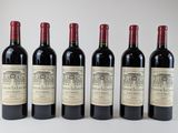 six bouteilles de vin sont alignées sur une surface blanche