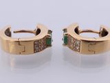a pair of gold earrings with emerald stones