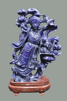 statue représentant une femme tenant un panier de fleurs, posée sur un socle en bois