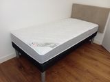 a small bed with a mattress on it in a room