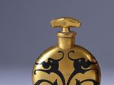 gold flaskt with black and white designs on it sitting on a white surface