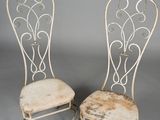 pair of antique white wrought chairs with upholstered seats