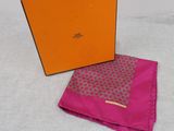 an orange box with a pink scarf and a pink handkerchief on a table