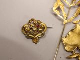 a gold brooch and a gold leaf on a table