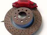 un gros plan sur un disque de frein rouge et un frein rouge