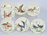 six plates with birds painted on them on display