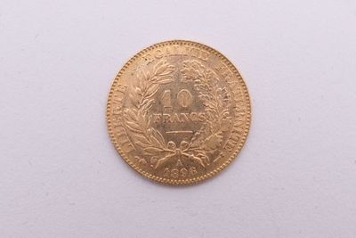 gros plan d'une pièce d'or sur une surface blanche
