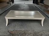 a white coffee table sitting in the middle of a parking lot