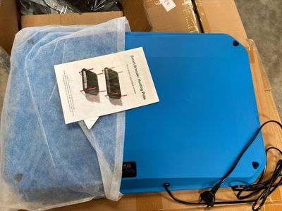 a blue laptop computer sitting on top of a cardboard box