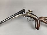 an old gun with a wooden handle on a white surface