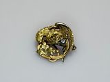 a gold brooch with a bird on it