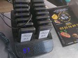 Plusieurs téléphones portables sont posés sur une table, à côté de nombreux chargeurs.
