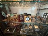 une vitrine en verre contenant une horloge et d'autres objets
