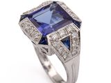 a close up of a blue sapphire and diamond ring on a white background