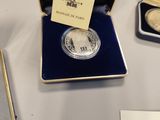 a silver coin sitting on a table next to a box
