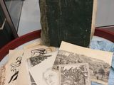 de nombreux livres anciens posés sur une table, avec une vitrine en arrière-plan