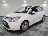 la petite voiture blanche est garée sur un sol en damier