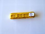 un lingot d'or posé sur une surface blanche