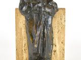 statue d'un homme assis sur un bloc de pierre, coiffé d'un chapeau