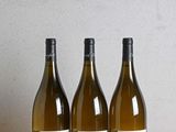 trois bouteilles de vin posées sur une table en bois