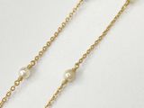 a gold chain with pearls on it