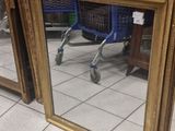 trois miroirs à cadre doré posés par terre dans un magasin