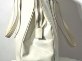 a white purse sitting on top of a white radiator