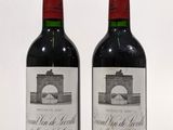 deux bouteilles de vin rouge posées l'une à côté de l'autre sur une surface blanche