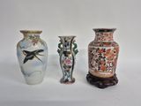 three vases with birds and flowers on them sitting next to each other