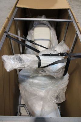 une boîte en carton contenant des toilettes, emballée dans du plastique