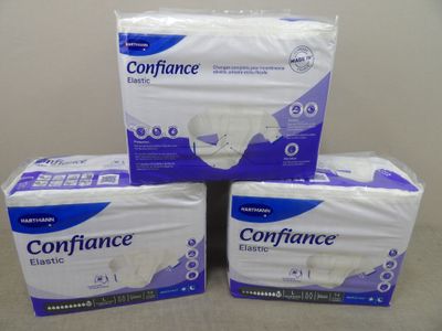 trois boîtes de serviettes hygiéniques empilées les unes sur les autres