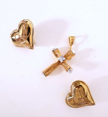 trois bijoux de couleur or sur une surface blanche