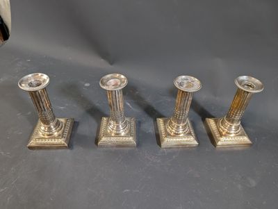 three silver candles are sitting on top of a table