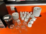 many cups and mugs on the orange table