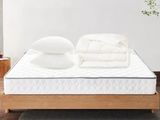 un lit avec des oreillers, sur lesquels sont posés d'autres oreillers, dans une chambre