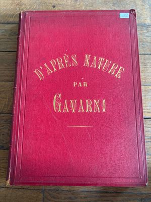 un vieux livre rouge posé sur une table en bois