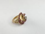 a close up of a gold ring with red and white stones