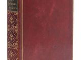 un vieux livre à la couverture rouge posé sur une surface blanche