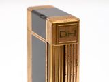 a gold and black lighter sitting on a white surface