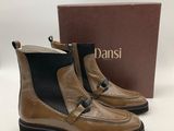 a pair of tan and black boots with a box in the background