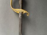 a close up of a sword on a gray surface