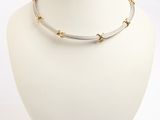 silver and gold plated necklace on a mannequin neck