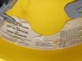 a yellow hard hat with a safety tag attached to it