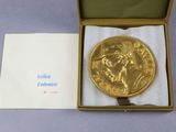 une médaille d'or posée dans une boîte sur une table