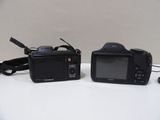 two cameras sitting next to each other on a table