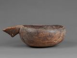 a close up of a wooden bowl on a gray surface