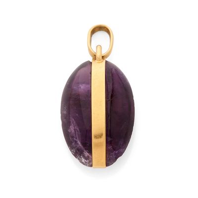 un gros plan d'un pendentif violet et doré sur fond blanc