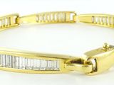 un gros plan sur un bracelet en or orné de pierres taillées en baguette