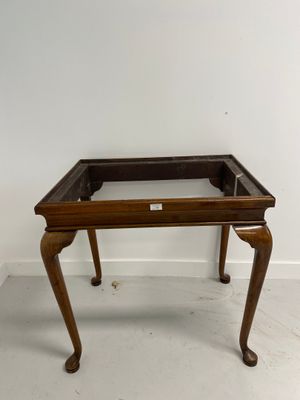 an old wooden table with a glass top and legs