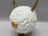 a white sheep with gold horns on it ' s head